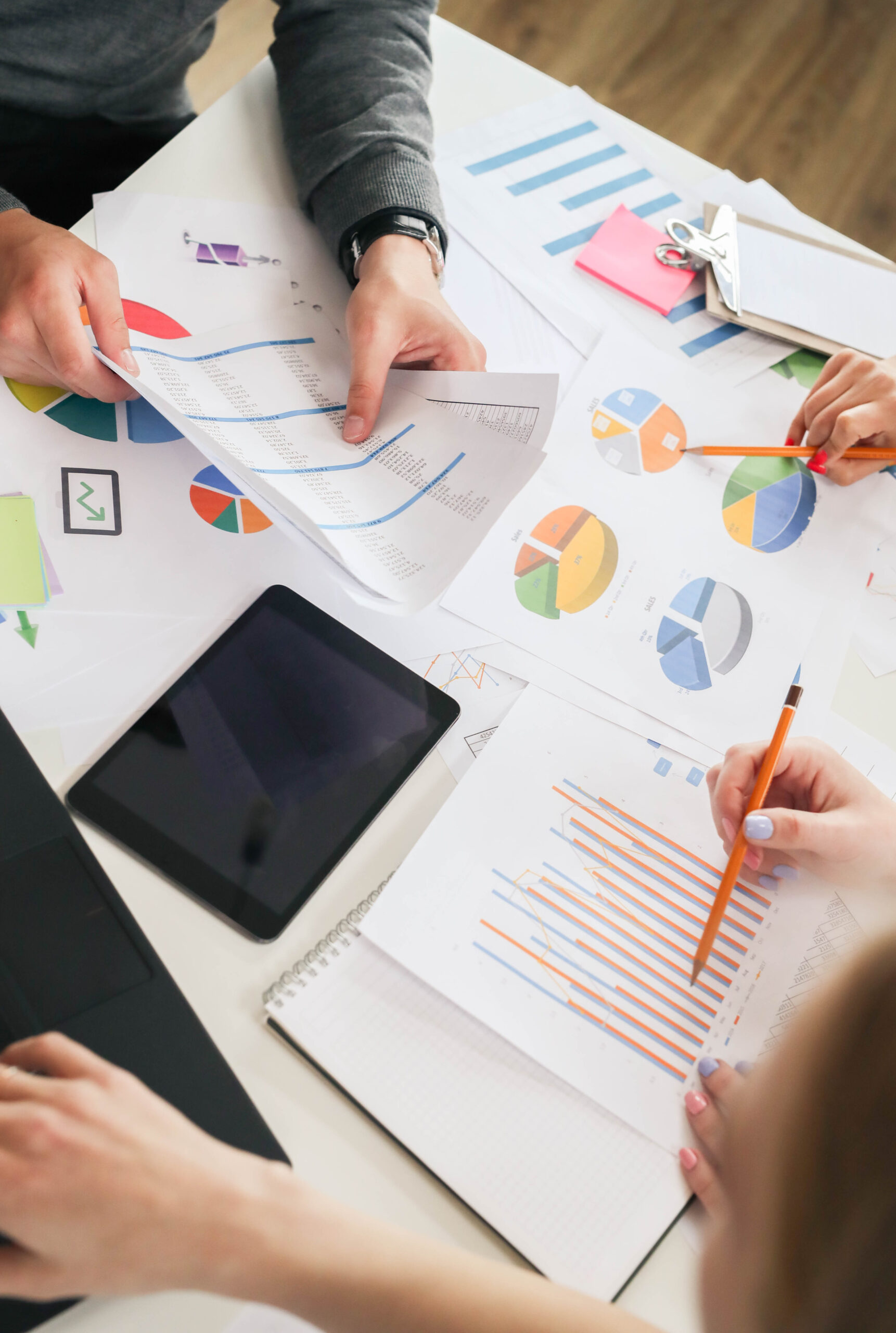 Business professionals discussing data charts and graphs in a modern office setting.